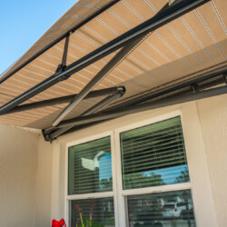 Retractable awning over window, sunny exterior view.