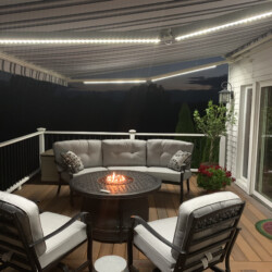 Outdoor seating area with fire pit at night.