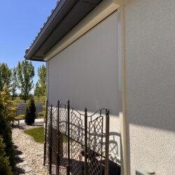 Outdoor patio with retractable sunshade and garden pathway.