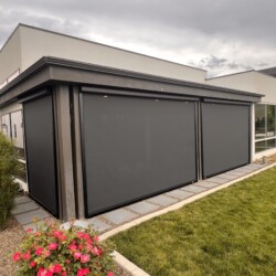 Modern building with shaded windows and garden view.