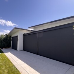 Modern house with black-shaded exterior and driveway